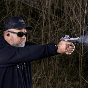 Man at outdoor shooting range using Gideon Optics Valor Mini Micro Red Dot on his pistol while practicing shooting